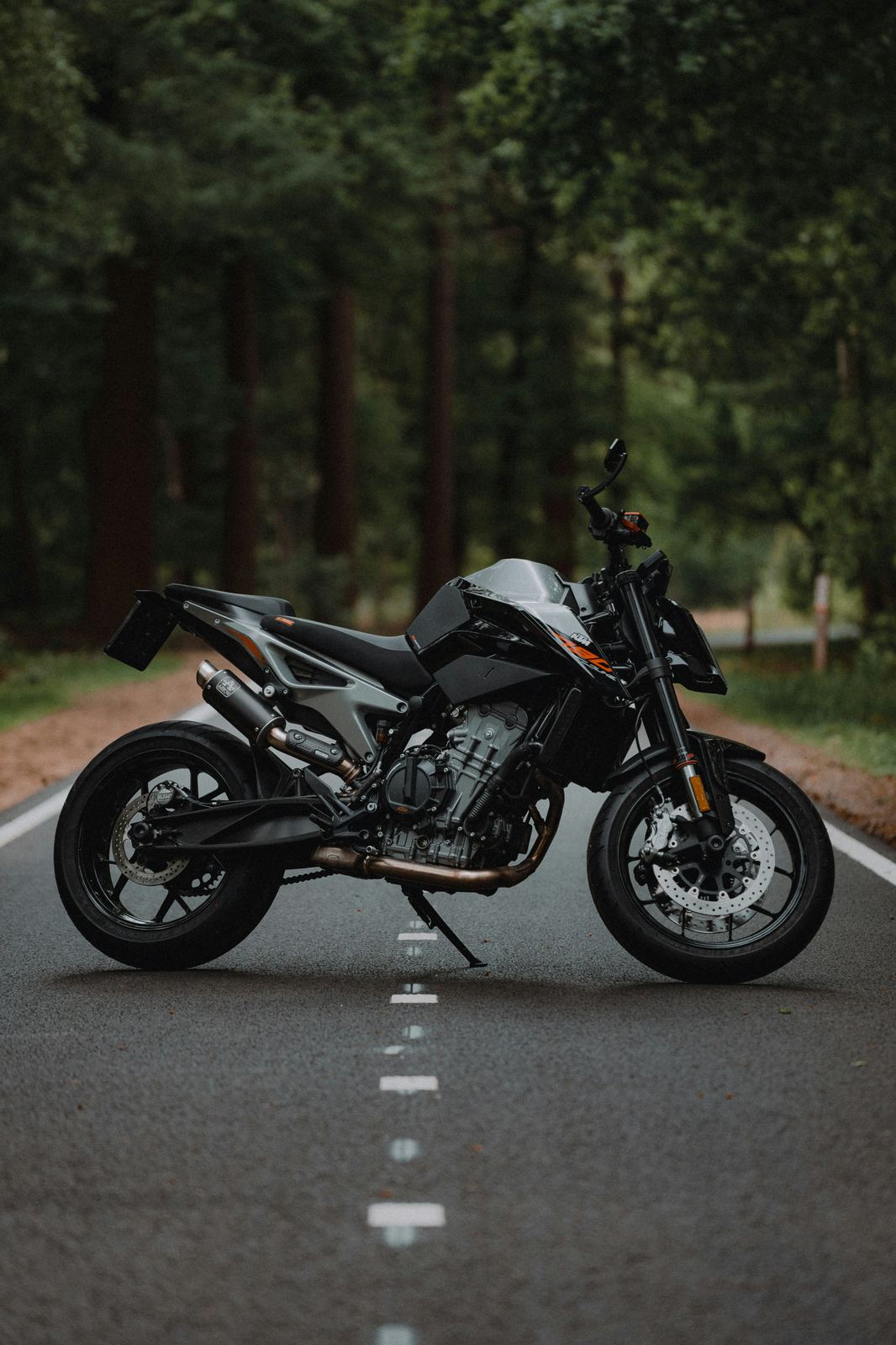 Moto KTM 790 vue de profil sur une route forestière