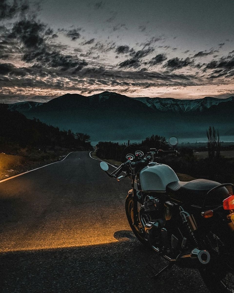 Rider confiant au coucher du soleil, moto entretenue par ses soins